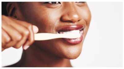 black woman brushing her teeth