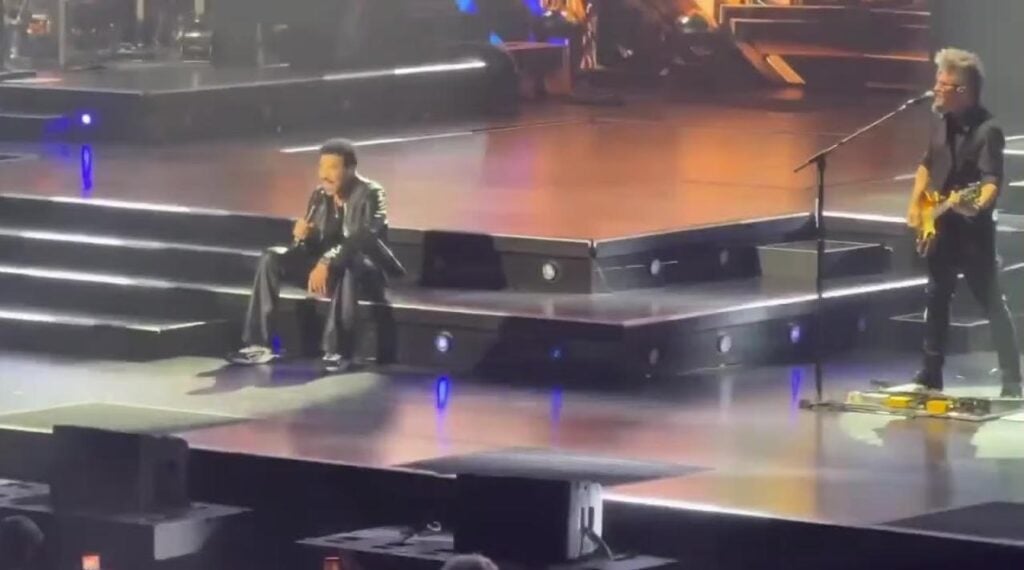 Lionel Richie sitting on stage after falling ill - screenshot