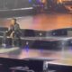 Lionel Richie sitting on stage after falling ill - screenshot