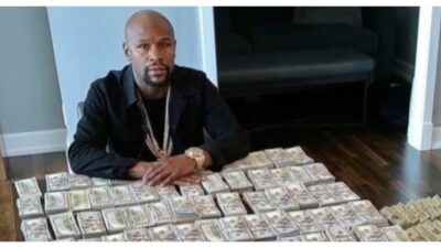 Floyd Mayweather sitting at a table with stacks of cash