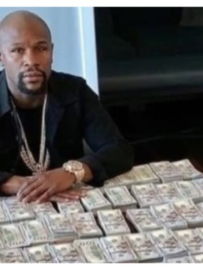 Floyd Mayweather sitting at a table with stacks of cash