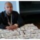 Floyd Mayweather sitting at a table with stacks of cash