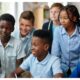 Students looking at computer screen inside a classroom via AI generated