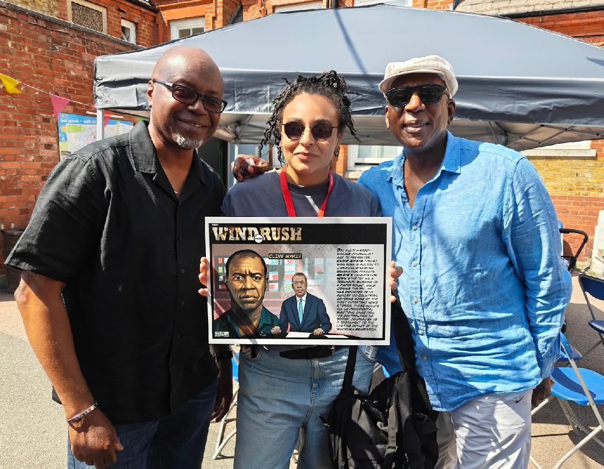 Tayo, Nelle Porter and actor Colin McFarlane both of Justice 4 Windrush with one of Tayo's donated illustrations to school