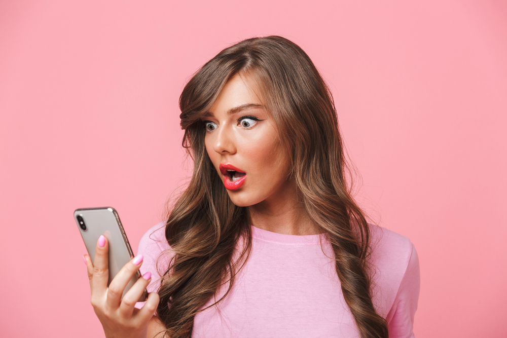 woman looking at smartphone with shocked expressions