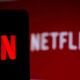 Netflix logo on smartphone and TV screen