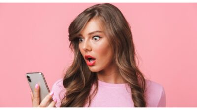 woman looking at smartphone with shocked expressions