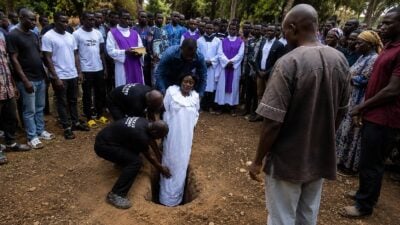 African woman being buried vertically - screenshot