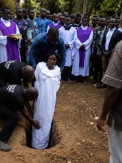 African woman being buried vertically - screenshot