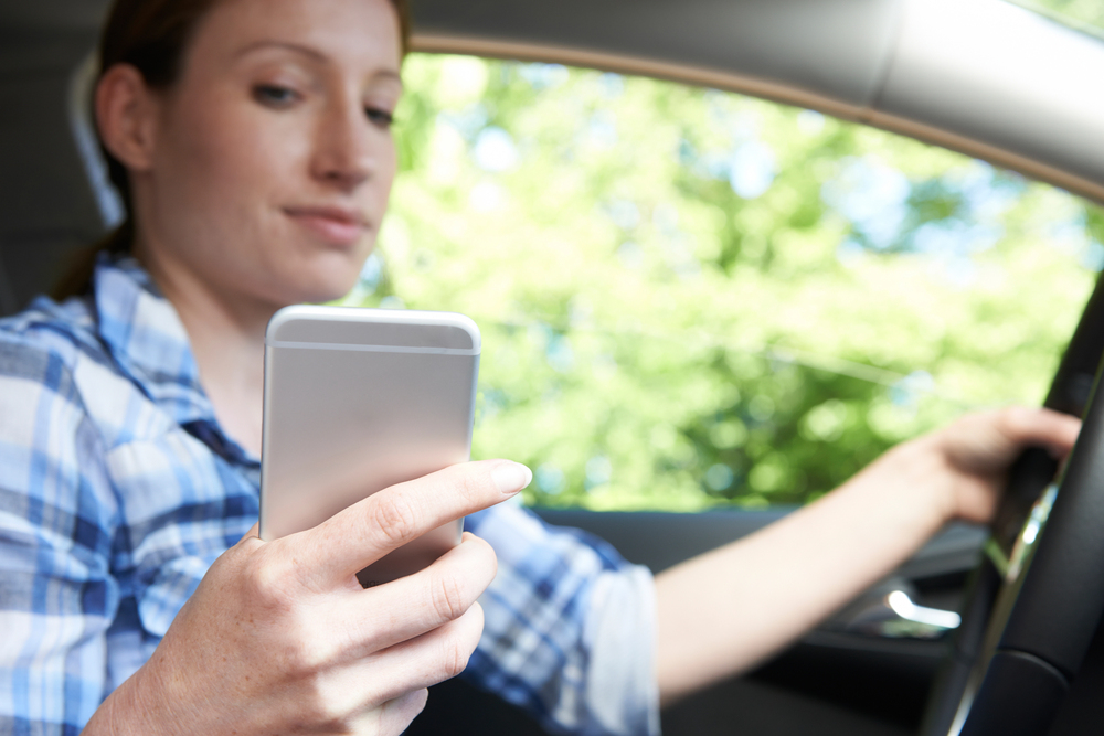 Woman In Car Texting on Mobile Phone Whilst Driving