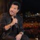 Lionel Richie seated onstage during a nighttime concert - via eurAI