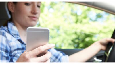 Woman In Car Texting on Mobile Phone Whilst Driving