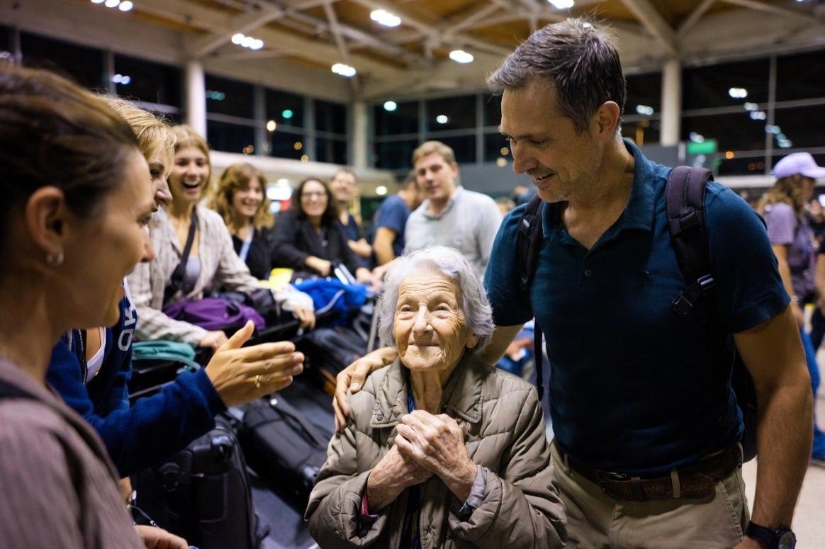 Passengers congratulate grandmother at baggage claim - via eurAI