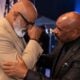 Editorial depiction of two Black comedians (Jonathan Slocumb and Steve Harvey) reconciling backstage