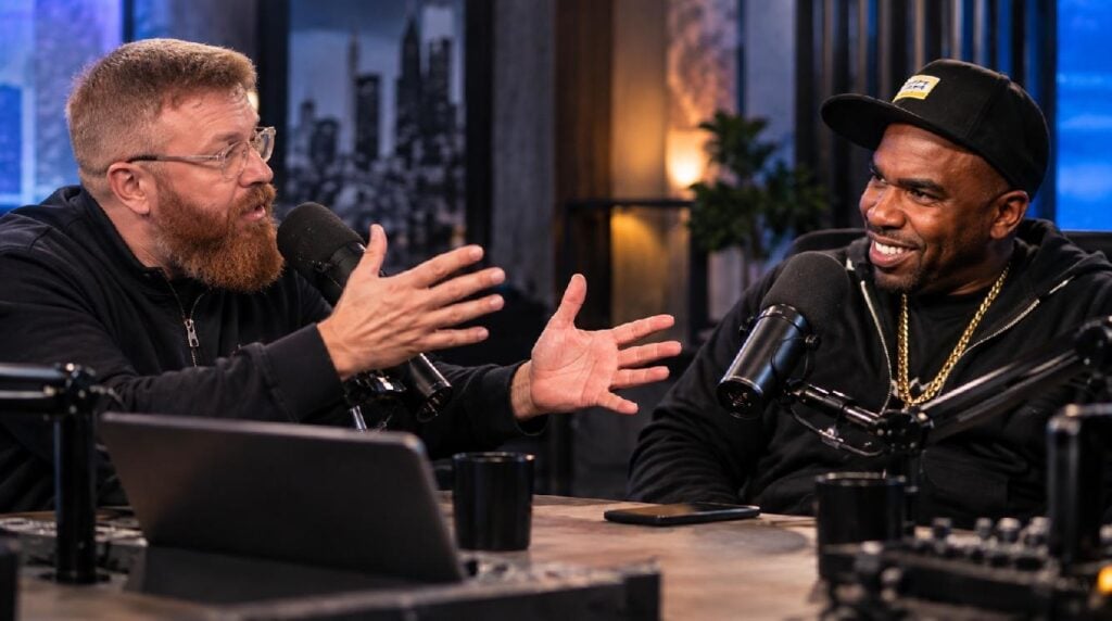 Editorial illustration of two media personalities (DJ Vlad and N.O.R.E.) arguing across microphones in a podcast studio