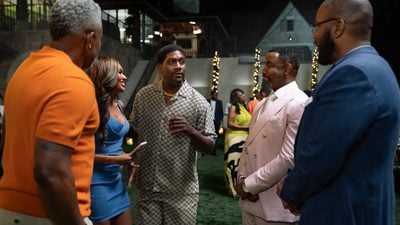 "Five adults dressed in stylish outfits stand talking and laughing at an outdoor evening party, with lights, greenery, and a large house visible in the background. The mood is friendly and festive."