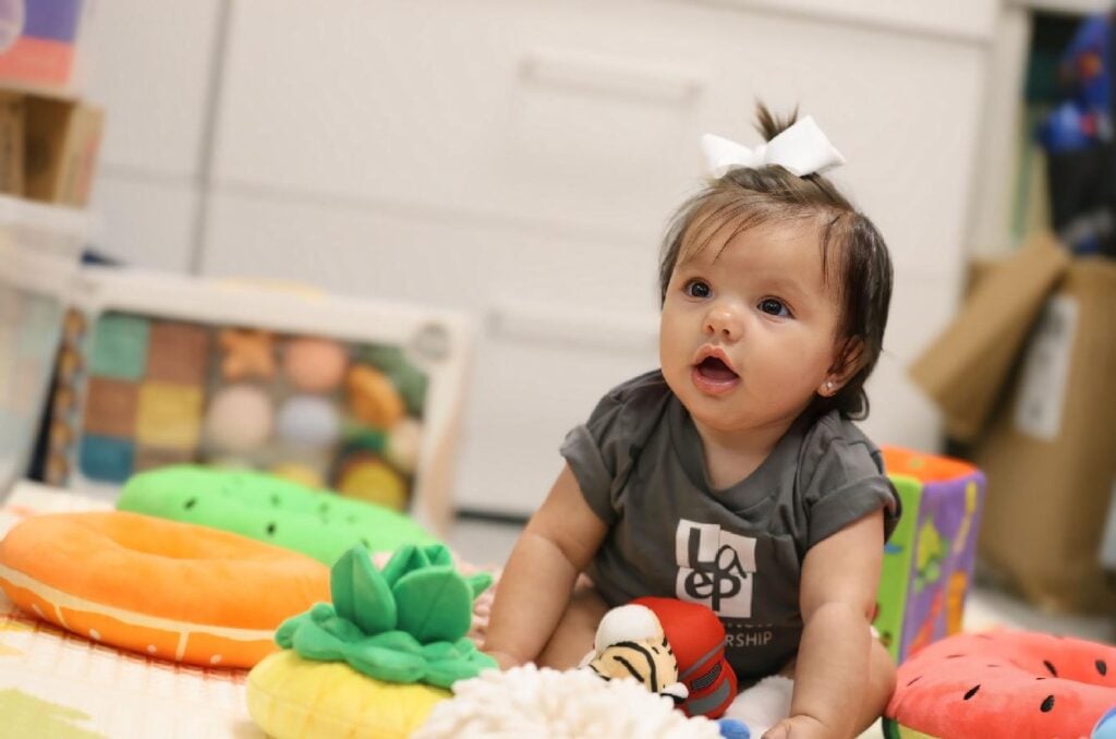 Baby explores colorful toys in early learning environment